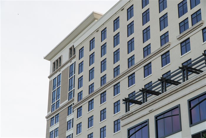 Upward view of a tall commercial building facade with rows of windows