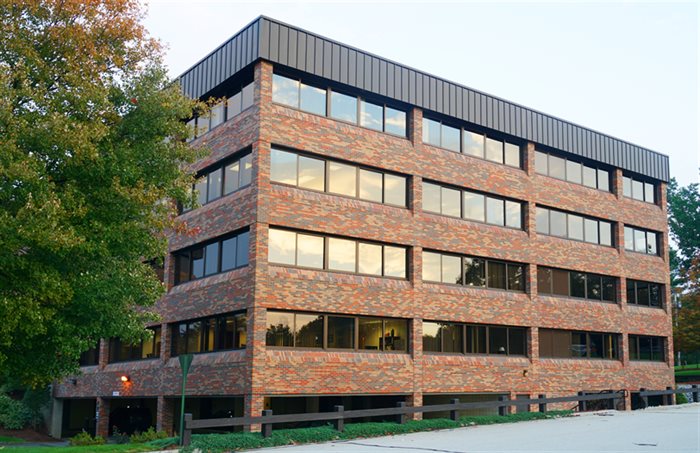Brick commercial office building with large windows on every floor